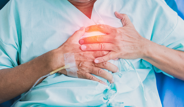 A senior patient receiving continuous vital sign monitoring from a nurse in a Senior care home for cardiac patients in India.